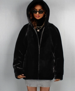 Detail of luxurious black faux fur texture on a hooded jacket with metal zipper closure