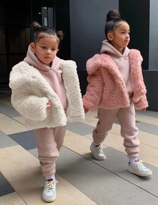Close-up of warm pink girls' hoodie and thick white faux fur teddy jacket for autumn