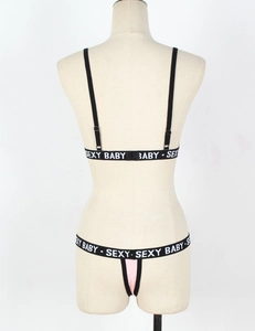 Detail of black lingerie set with Sexy Baby logo on elastic bands from back view