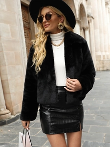Detail of black faux fur cropped jacket with soft texture and chic metal jewelry