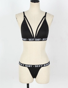 Detailed close-up of sexy black lingerie set featuring elastic white lettered straps