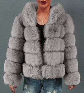 Detail of grey faux fur coat featuring layered horizontal panels and a large plush hood