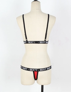Detail of the elastic waistband with 'SEXY BABY' lettering on a black and red lingerie set