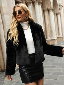 Street style shot of a woman in a black faux fur jacket and crocodile skin leather skirt