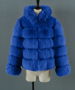 Detailed view of layered electric blue faux fur coat with hood on mannequin