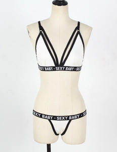 Detail of white lingerie set with black Sexy Baby lettered elastic band on mannequin