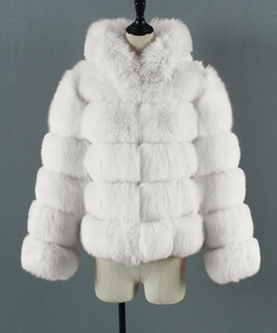 Detailed close-up of white faux fur coat featuring horizontal segmented plush texture