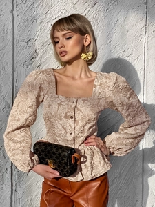 Detailed close-up of beige floral jacquard fabric texture and square neck design on shirt