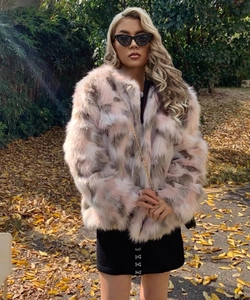 Detail of pink and white faux fox fur coat texture with plush long sleeves style