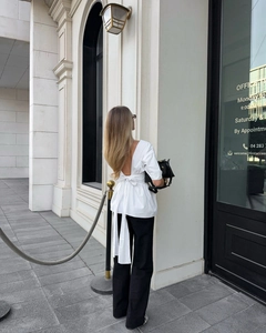 Haut blanc élégant dos nu avec un grand nœud papillon et une coupe en V sophistiquée