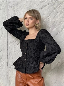 Close-up of black jacquard fabric texture and square collar on French puff sleeve shirt