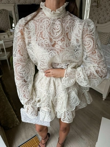 Dettaglio dell'elegante set in pizzo con motivi paisley e maniche a lanterna