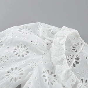 Dettaglio del complesso ricamo inglese bianco e dello scollo smerlato sul top in cotone