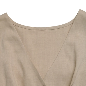 Detail shot of the V-neckline and fine twill fabric on the khaki sleeveless jumpsuit