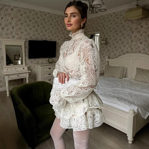 Elegante set di top bianco in pizzo a maniche lunghe e minigonna a trapezio per l'estate