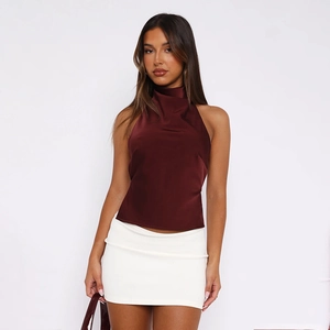 Détail d'un haut licou en satin bordeaux brillant avec une mini-jupe moulante blanche