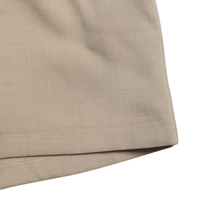 Detailed view of the khaki jumpsuit's hem with clean stitching and premium finish