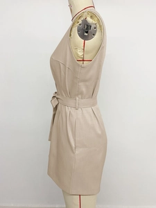 Detail view of beige sleeveless romper featuring a tie waist belt and woven texture fabric