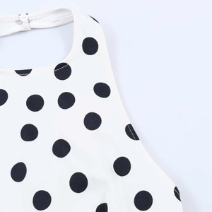 Detail des Polka-Dot-Halter-Tops mit Nackenverschluss und weißem Knopf auf Stoff