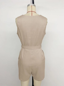 Rear view of beige sleeveless romper featuring a cinched waist and textured linen fabric