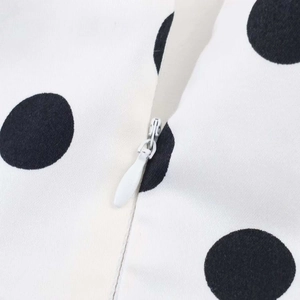 Detailansicht eines weißen Oberteils mit Polka Dots und einem unsichtbaren Reißverschluss