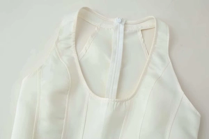 Detailaufnahme des weißen Halter-Tops mit seidiger Textur und verdecktem Reißverschluss