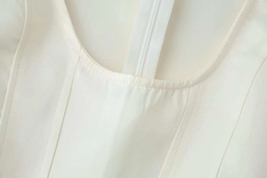 Details zu Nähten und Reißverschluss an einem cremefarbenen Neckholder-Top für Damen