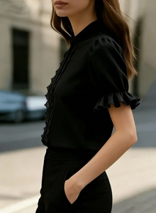 Detail of elegant black lace stand collar and puff sleeves on a chiffon summer shirt