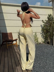 Detail of yellow striped halter top with open back and wide leg pants back view
