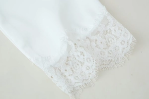 Close-up of elegant white silky fabric featuring intricate eyelash lace trim detailing
