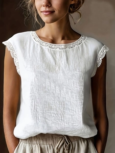 Detail of white linen top featuring intricate lace trim on the neckline and sleeve cuffs