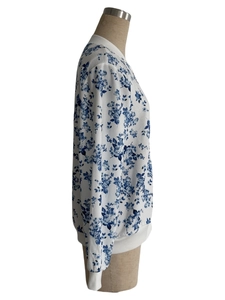 Detail of zipper baseball collar jacket with blue floral pattern on white fabric