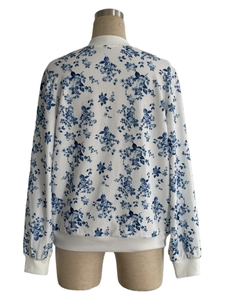 Detail view of the white jacket back featuring blue floral prints and ribbed hems