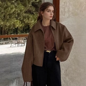 Close-up of a dark brown cropped jacket featuring a lapel collar and zip-up design