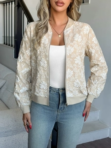 Dettaglio del ricamo floreale bianco e dei polsini a costine sulla giacca bomber beige
