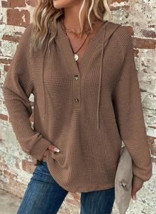 Detail of waffle knit fabric on brown hoodie with V-neck buttons and drawstring hood