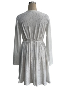 Detail of white mini dress featuring intricate hollow embroidery and elastic waist back