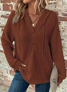 Detail of waffle knit fabric on a V-neck hoodie with wood buttons and drawstrings