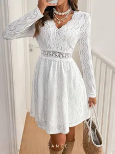 Detail of elegant white V-neck mini dress with intricate eyelet lace and scalloped edges