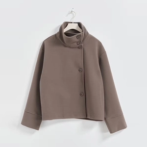 Detail of elegant stand collar jacket with side button closure in warm coffee brown