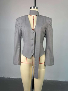Détail d'un blazer court gris avec col écharpe élégant et fermeture à boutons