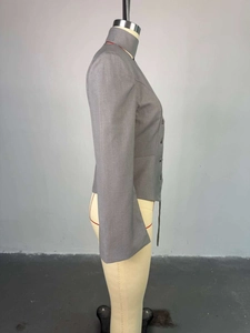 Détail d'un blazer court gris foncé avec col montant et fermeture à double boutonnage