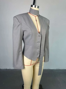 Détail de la veste blazer grise à col en V avec accessoire choker assorti
