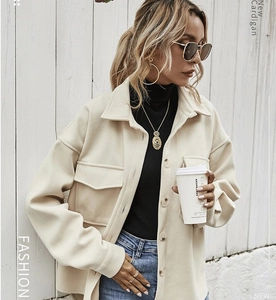 Dettaglio della giacca in lana beige con bottoni, tasche a patta e colletto classico