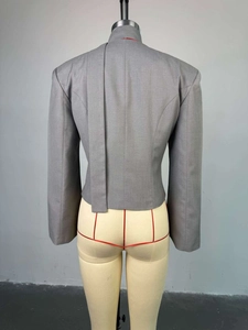Détail de la découpe asymétrique au dos et de la longue sangle sur un blazer gris chic