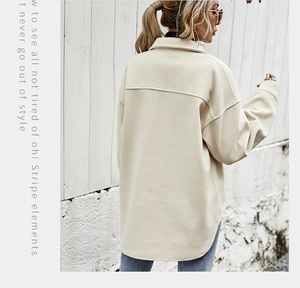 Dettaglio della giacca a camicia beige oversize con spalle scese e fondo arrotondato