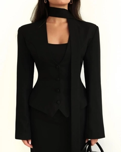Détail d'un blazer noir cintré avec col en V profond et accessoire écharpe assorti