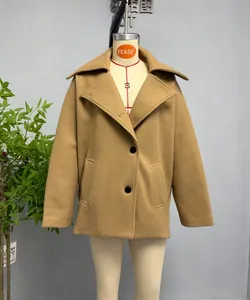 Detail of camel wool blend coat featuring a large lapel and minimalist double button closure