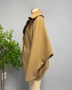 Detail view of camel wool blend coat featuring large side pockets and lapel collar