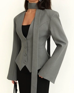 Détail d'un blazer gris avec col en V, tour de cou unique et élégantes longues écharpes